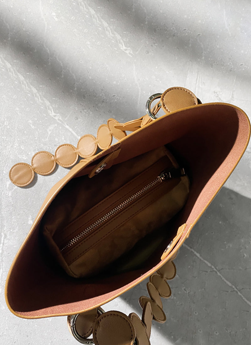 ISOLE公式｜ブラウン色の円形デザインハンドバッグ、ストラップつき、おしゃれ