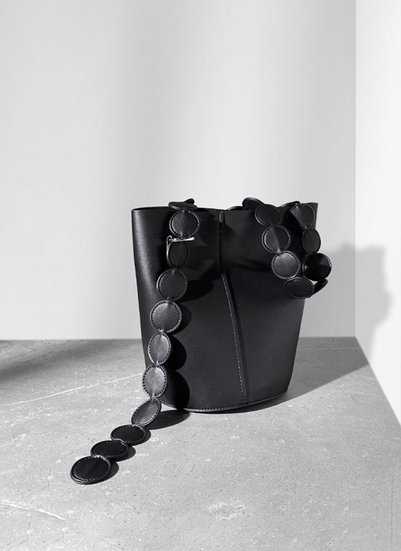 ISOLE公式｜ストラップがついたブラック色の円型デザインハンドバッグ