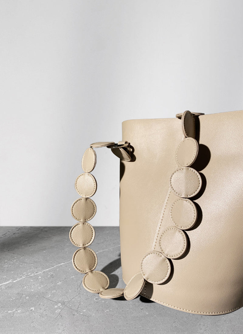 ISOLE公式｜ベージュ色のオシャレな円型デザインハンドバッグ、ストラップ付