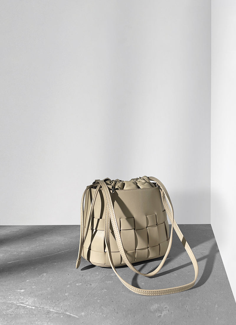 ISOLE公式｜薄いベージュ色のショルダーバッグ、巾着タイプ、編み込みデザイン